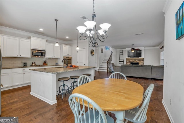 3890 Pleasant Woods Dr, Cumming, GA 30028 - dining space with stairs, a fireplace, visible vents, and ornamental molding