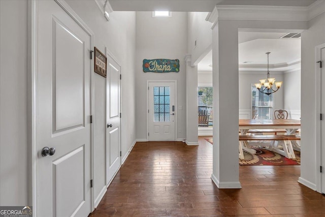 3890 Pleasant Woods Dr, Cumming, GA 30028 - foyer with dark wood-style floors, crown molding, visible vents, an inviting chandelier, and baseboards