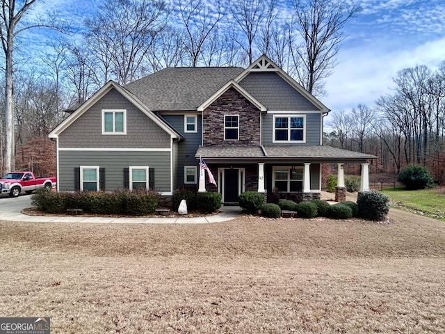 craftsman-style house featuring stone siding, a porch, and a shingled roof