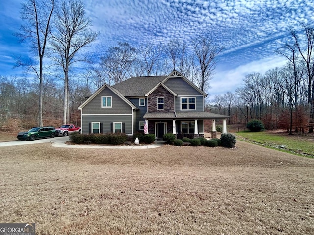 craftsman-style home with roof with shingles and covered porch