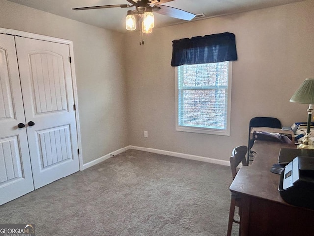 carpeted office space with baseboards and ceiling fan
