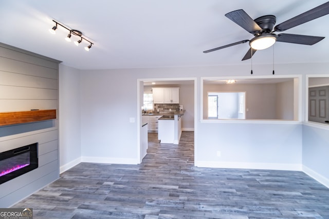 unfurnished living room featuring dark hardwood / wood-style floors and ceiling fan