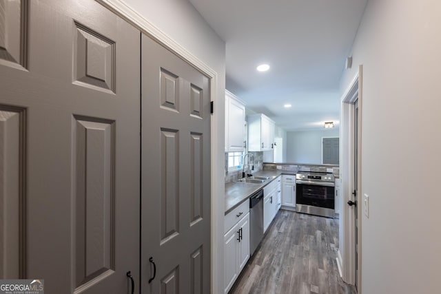 kitchen with dark wood-type flooring, sink, tasteful backsplash, appliances with stainless steel finishes, and white cabinets