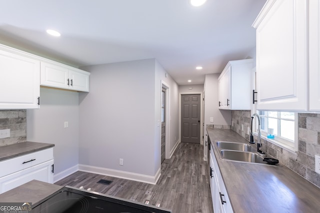 kitchen featuring sink, backsplash, white cabinets, and dark hardwood / wood-style floors