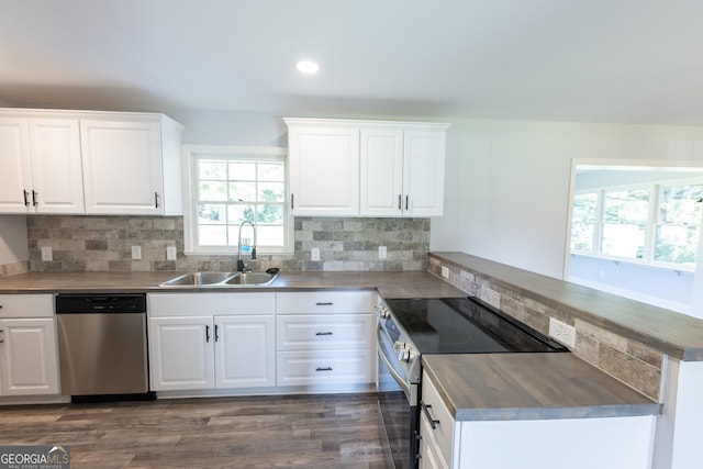 kitchen with sink, white cabinetry, tasteful backsplash, appliances with stainless steel finishes, and kitchen peninsula