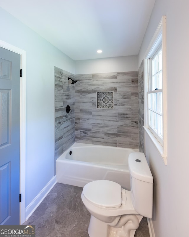 bathroom with tiled shower / bath and toilet