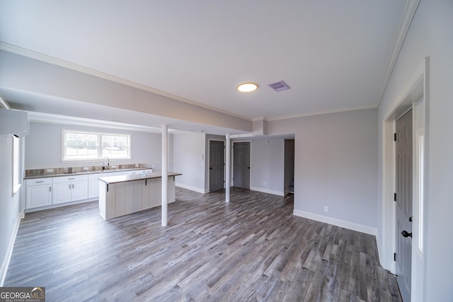 kitchen with sink, crown molding, a wall mounted air conditioner, light hardwood / wood-style floors, and white cabinets