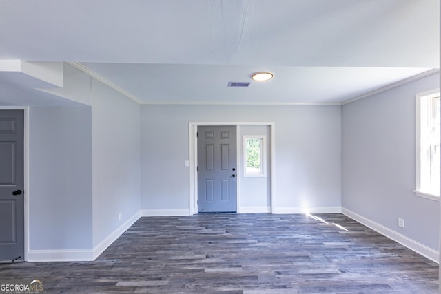 spare room with ornamental molding and dark hardwood / wood-style flooring