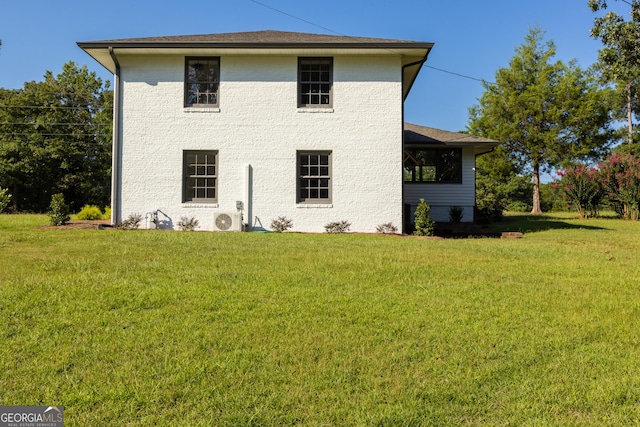 back of house featuring a yard and ac unit