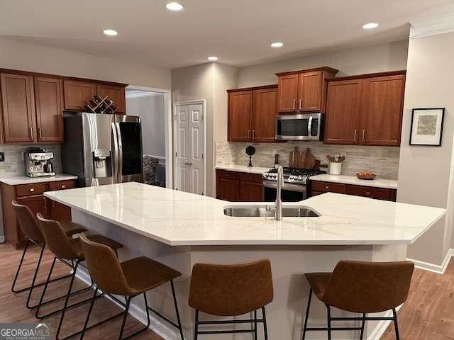 kitchen featuring sink, a center island with sink, and appliances with stainless steel finishes