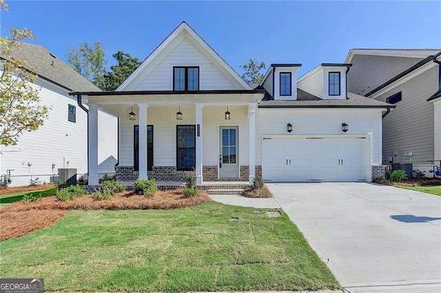 view of front of property featuring cooling unit, a garage, covered porch, and a front yard