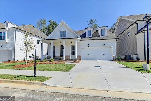 view of front of house with a garage, covered porch, a front yard, and central air condition unit