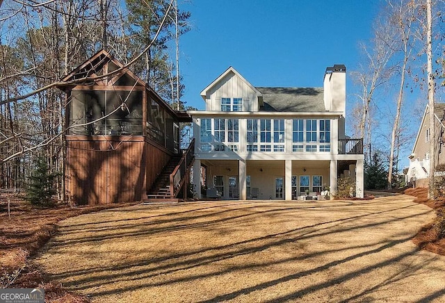 rear view of house with a sunroom and a lawn