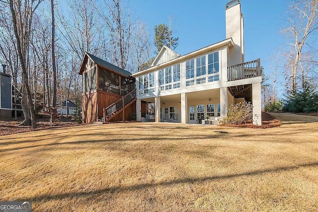 back of property featuring a yard and a sunroom