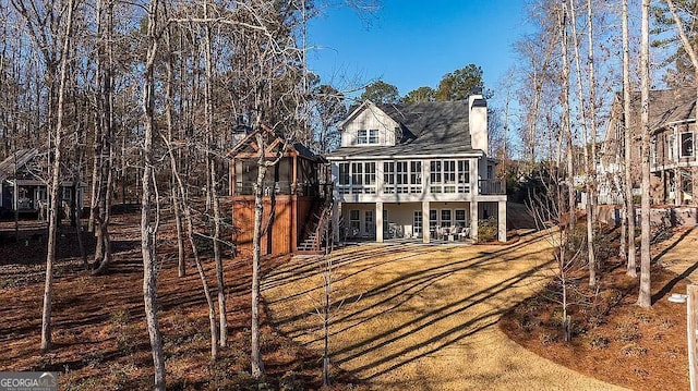 rear view of house featuring a sunroom