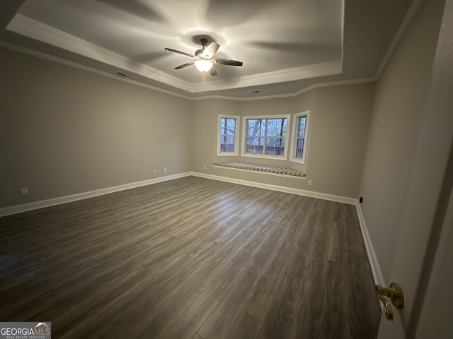 unfurnished room featuring ceiling fan, ornamental molding, dark hardwood / wood-style flooring, and a raised ceiling