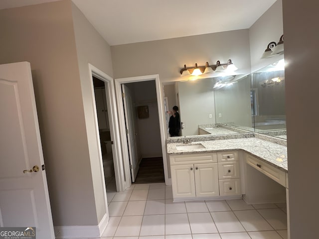 bathroom featuring vanity, tile patterned floors, and toilet