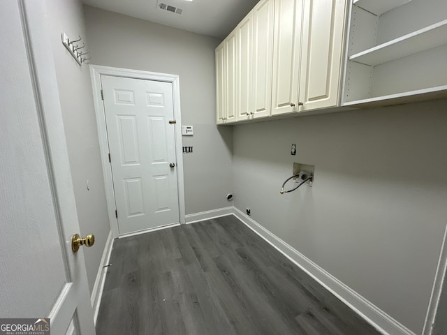 washroom featuring washer hookup, electric dryer hookup, dark hardwood / wood-style floors, and cabinets