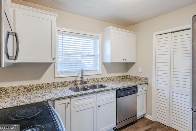 kitchen featuring white cabinetry, sink, light stone counters, and appliances with stainless steel finishes