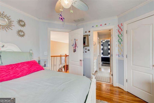 bedroom with crown molding, ceiling fan, and light wood-type flooring