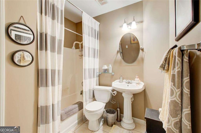 bathroom featuring tile patterned flooring, shower / tub combo, and toilet