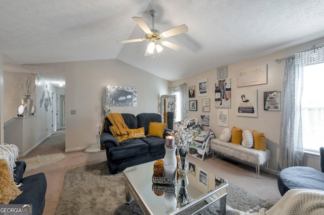 living room featuring lofted ceiling, a textured ceiling, a healthy amount of sunlight, and carpet