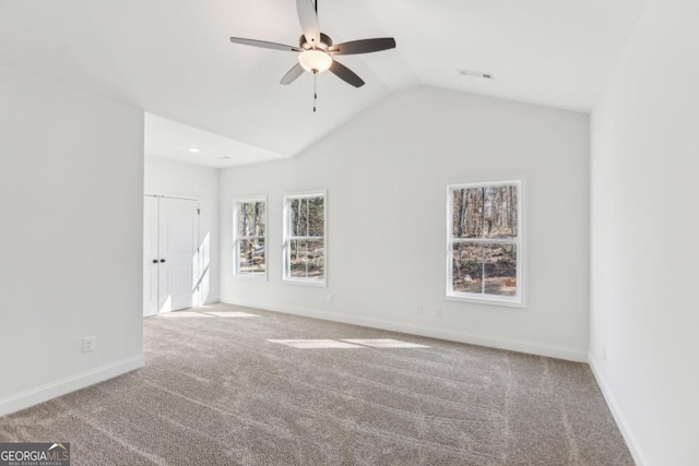 carpeted spare room with vaulted ceiling and ceiling fan