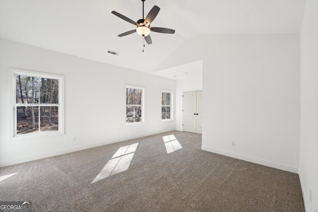 unfurnished room with dark carpet, plenty of natural light, high vaulted ceiling, and ceiling fan