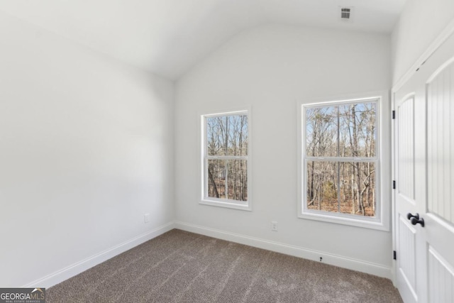 carpeted empty room with vaulted ceiling