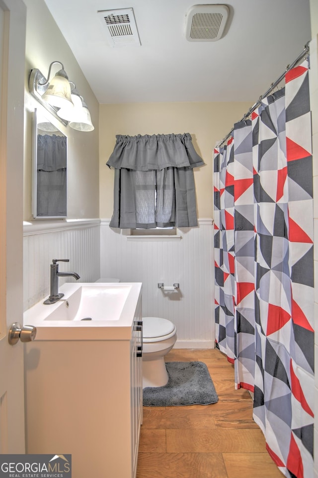 bathroom featuring vanity, toilet, and hardwood / wood-style floors