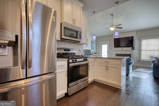 kitchen featuring light stone counters, white cabinetry, stainless steel appliances, and a healthy amount of sunlight