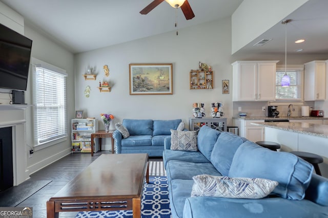 living room featuring lofted ceiling, sink, dark hardwood / wood-style floors, and ceiling fan