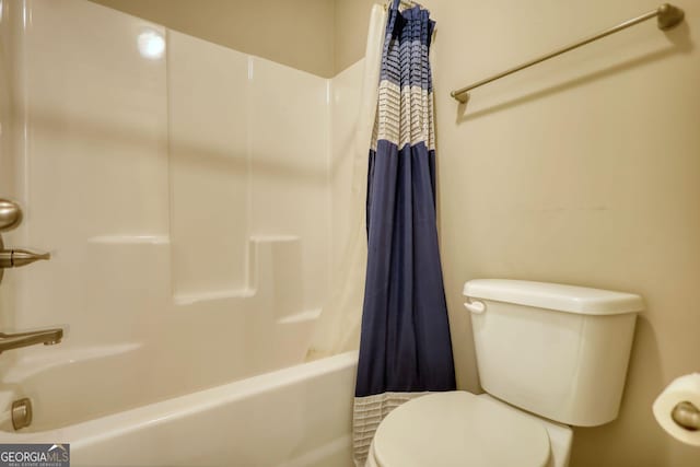 bathroom featuring shower / bath combo with shower curtain and toilet