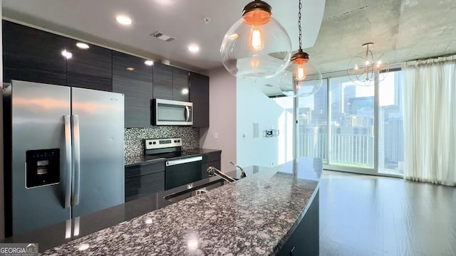 kitchen featuring dark cabinetry, visible vents, stainless steel appliances, and a sink