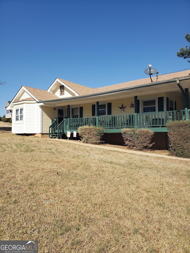 single story home with covered porch and a front yard