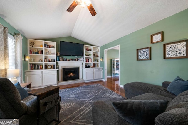 living room featuring vaulted ceiling, dark hardwood / wood-style floors, ceiling fan, and a textured ceiling