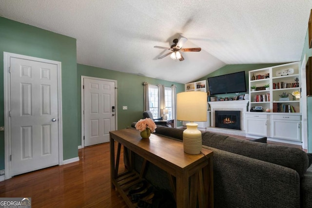 living room with hardwood / wood-style floors, vaulted ceiling, a textured ceiling, and ceiling fan