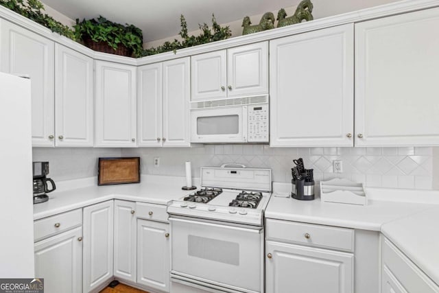 kitchen with white appliances, decorative backsplash, and white cabinets