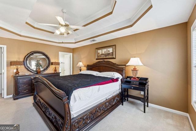 carpeted bedroom featuring crown molding, ceiling fan, a tray ceiling, and ensuite bath