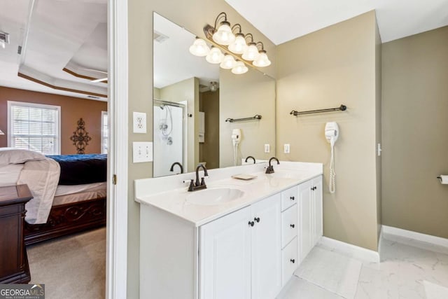 bathroom featuring vanity, a shower with shower door, and a raised ceiling