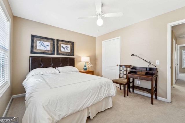 carpeted bedroom featuring multiple windows and ceiling fan