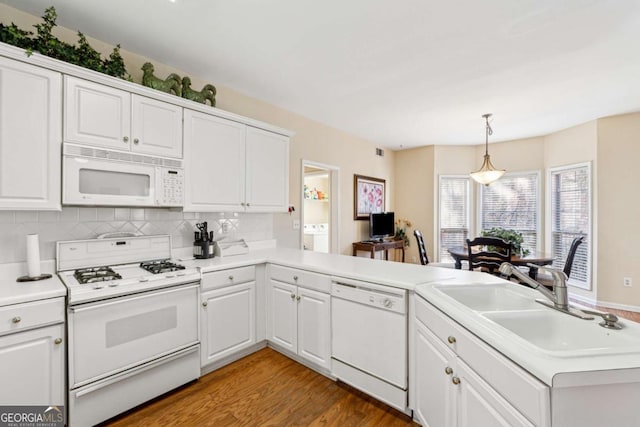 kitchen with decorative light fixtures, sink, white cabinets, kitchen peninsula, and white appliances