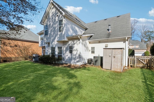 back of property featuring a lawn and central air condition unit