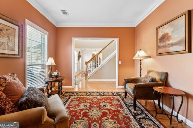 sitting room with ornamental molding and light hardwood / wood-style flooring