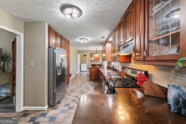 kitchen with sink, hanging light fixtures, kitchen peninsula, stainless steel appliances, and washer / clothes dryer