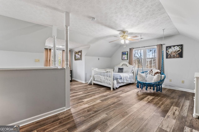 bedroom featuring hardwood / wood-style flooring, ceiling fan, lofted ceiling, and a textured ceiling