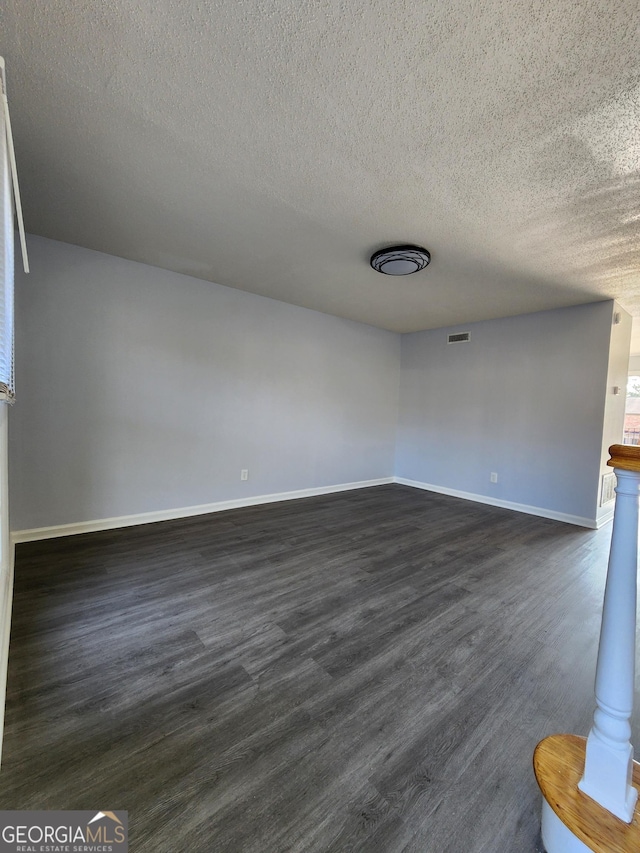 interior space featuring dark wood-type flooring and a textured ceiling