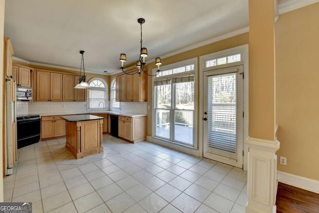 kitchen featuring crown molding, dishwasher, stove, hanging light fixtures, and a kitchen island