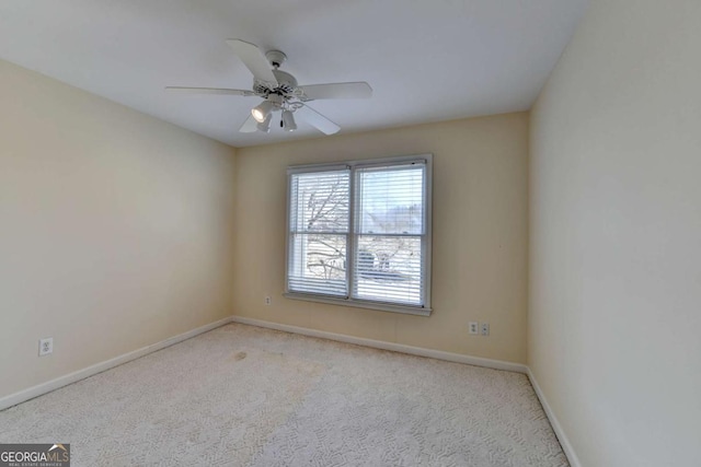 spare room featuring light carpet and ceiling fan