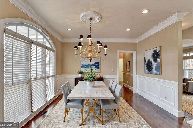 dining area featuring ornamental molding, a notable chandelier, and dark hardwood / wood-style flooring